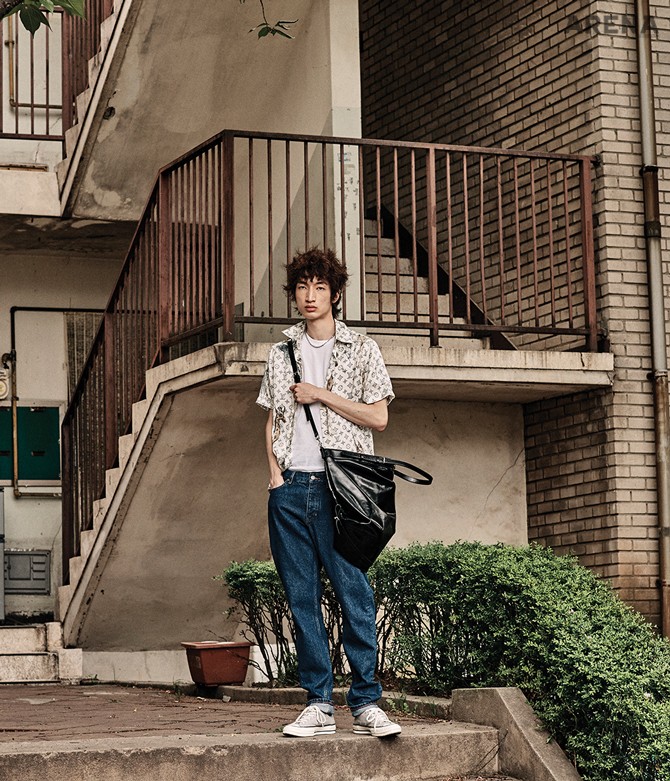 로고 프린트로 뒤덮인 실크 소재 셔츠 가격미정 루이 비통, 진청색 데님 팬츠 13만5천원 코스, 큼직한 검은색 크로스백 가격미정 생 로랑 by 안토니 바카렐로, 회색 슈즈 8만9천원 컨버스, 흰색 티셔츠·체인 목걸이 에디터 소장품.